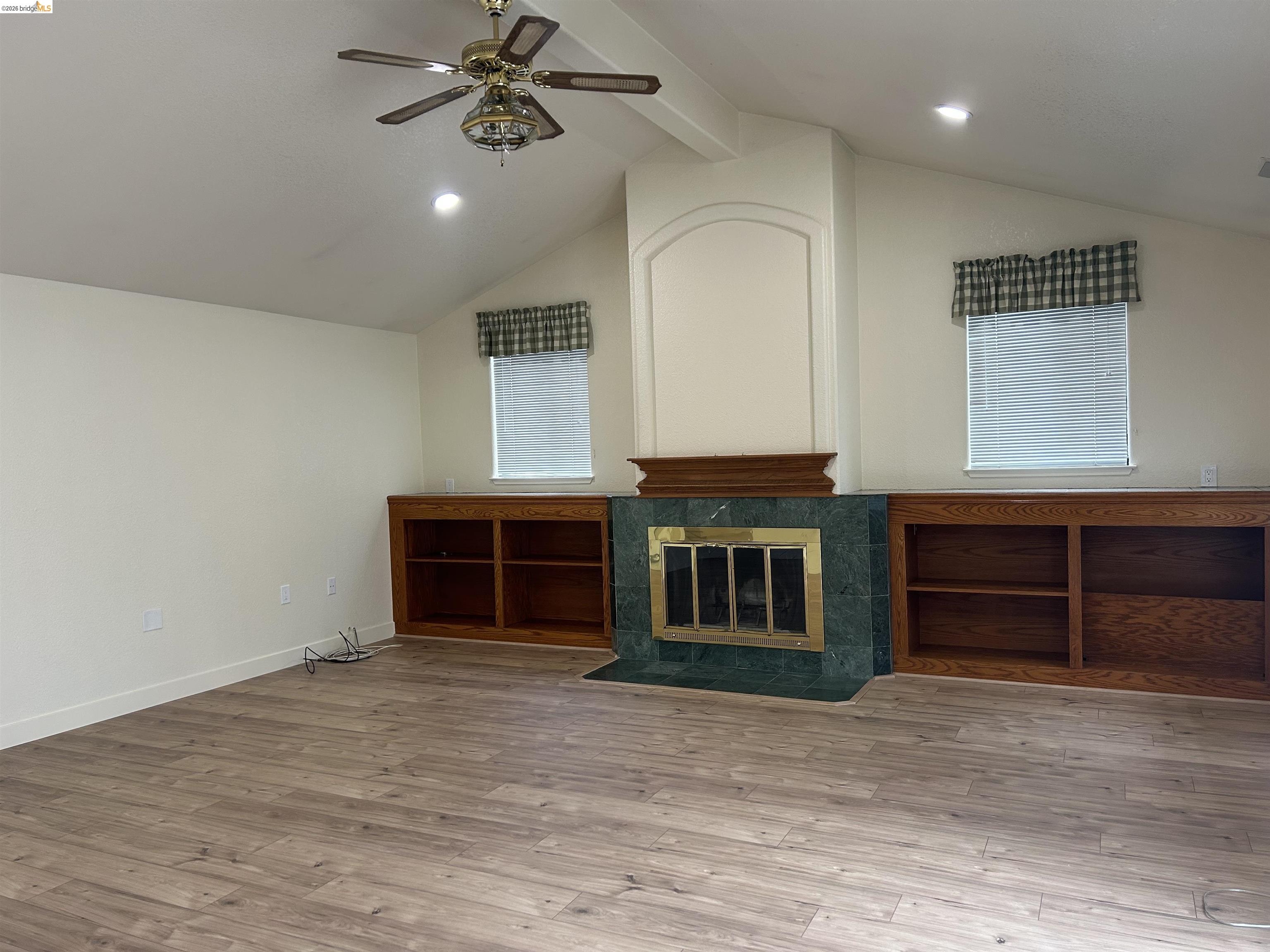 2632 Point Lobos Court Antioch, CA 94531 - Photo 12 of 27 Unfurnished living room featuring ceiling fan, light wood-style flooring, recessed lighting, a tile fireplace, and beam ceiling