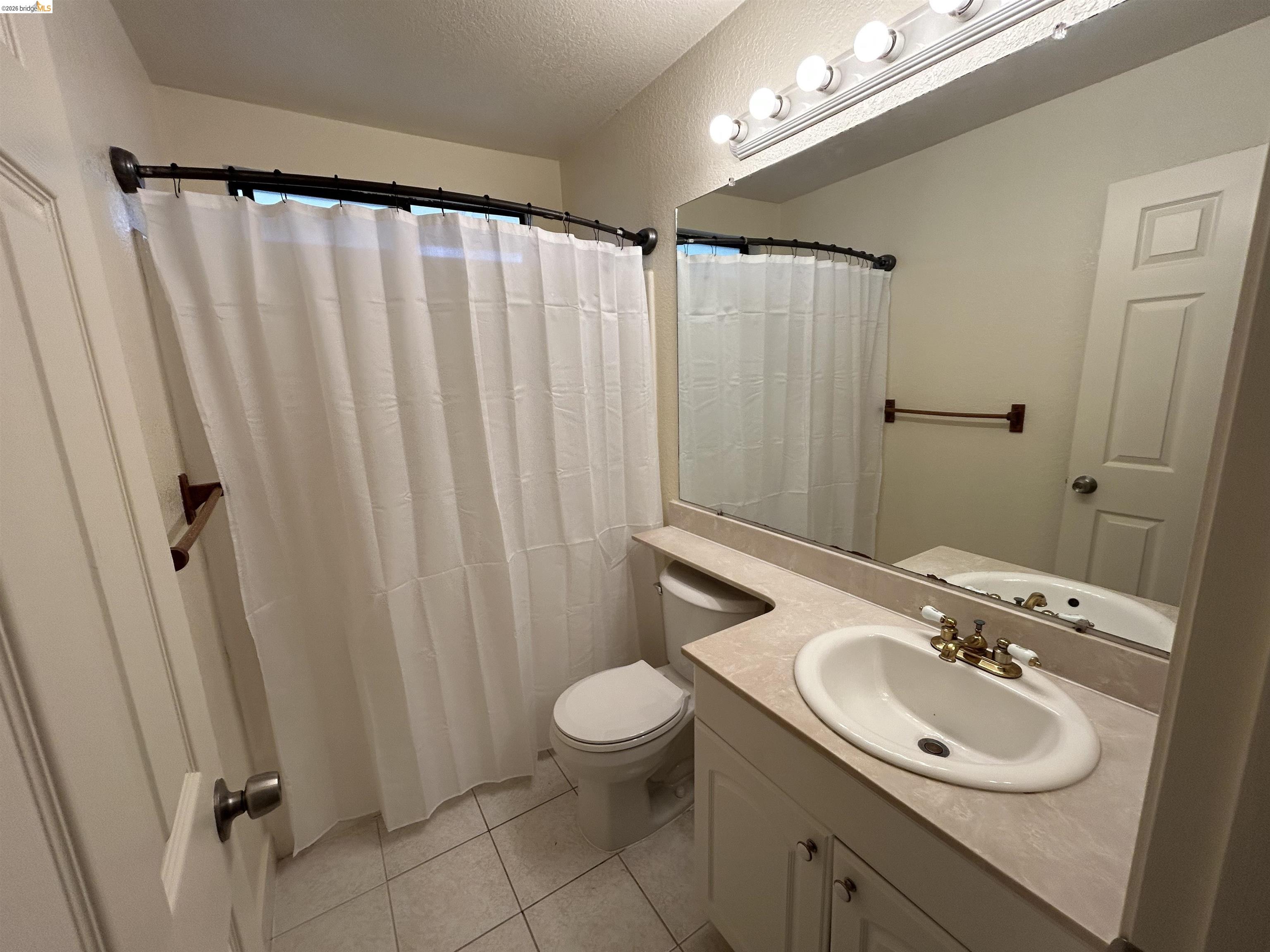 2632 Point Lobos Court Antioch, CA 94531 - Photo 16 of 27 Bathroom featuring vanity, a shower with shower curtain, light tile patterned floors, and a textured ceiling