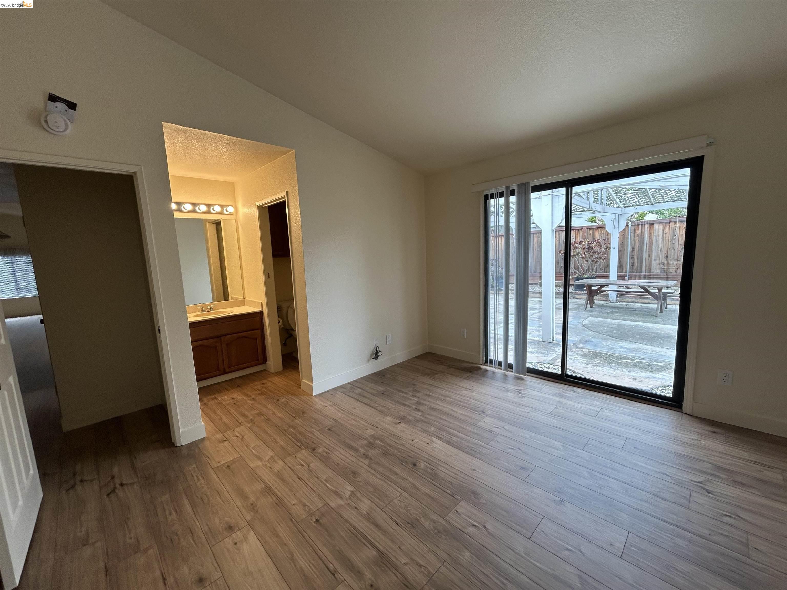 2632 Point Lobos Court Antioch, CA 94531 - Photo 20 of 27 Unfurnished bedroom featuring lofted ceiling, access to exterior, dark wood-type flooring, and connected bathroom