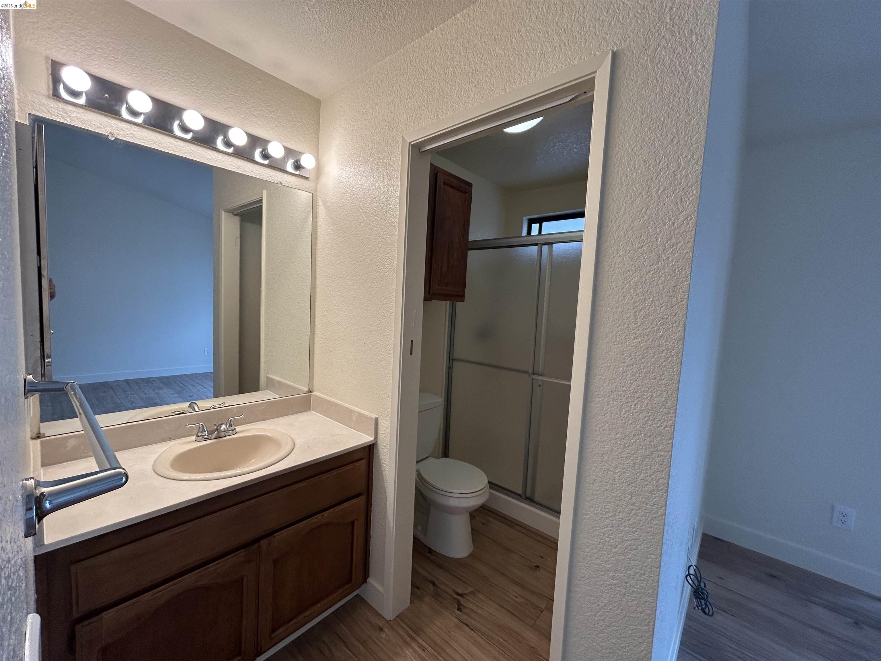 2632 Point Lobos Court Antioch, CA 94531 - Photo 21 of 27 Bathroom with a textured wall, vanity, a stall shower, light wood-type flooring, and a textured ceiling