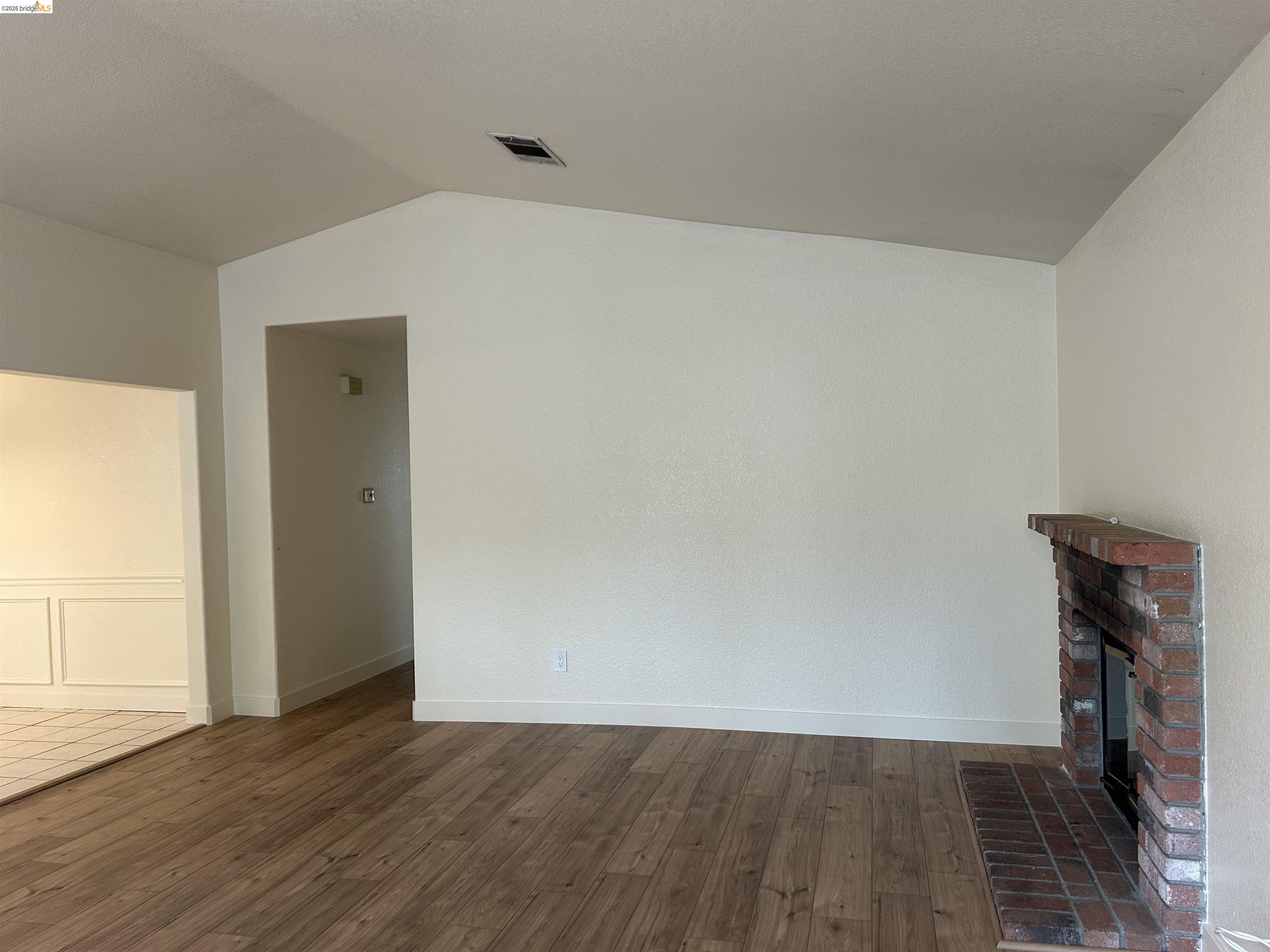 2632 Point Lobos Court Antioch, CA 94531 - Photo 3 of 27 Unfurnished living room featuring dark wood-style flooring, a fireplace, and lofted ceiling