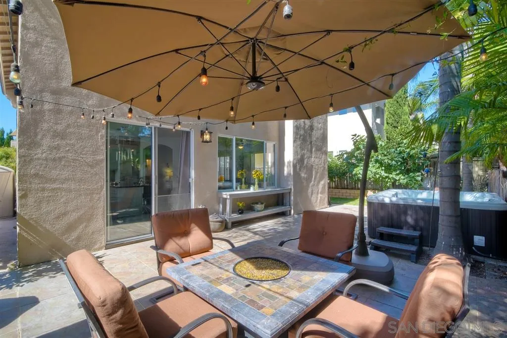11564 Village Ridge Road San Diego, CA 92131 - Photo 22 of 25 a patio with a table and chairs under an umbrella