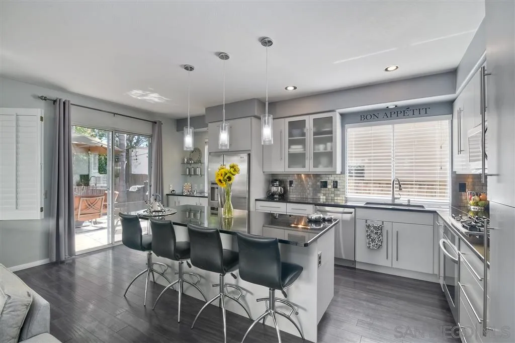 11564 Village Ridge Road San Diego, CA 92131 - Photo 10 of 25 a kitchen with a table chairs and wooden cabinets
