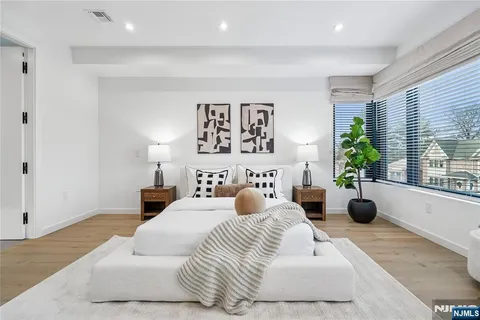 a bedroom with a bed a couch and potted plant