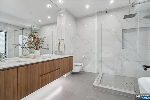a bathroom with a double vanity sink toilet and shower