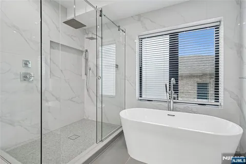a white bath tub sitting next to a shower