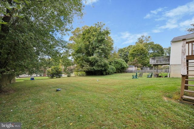 a view of a white house with a yard and a deck