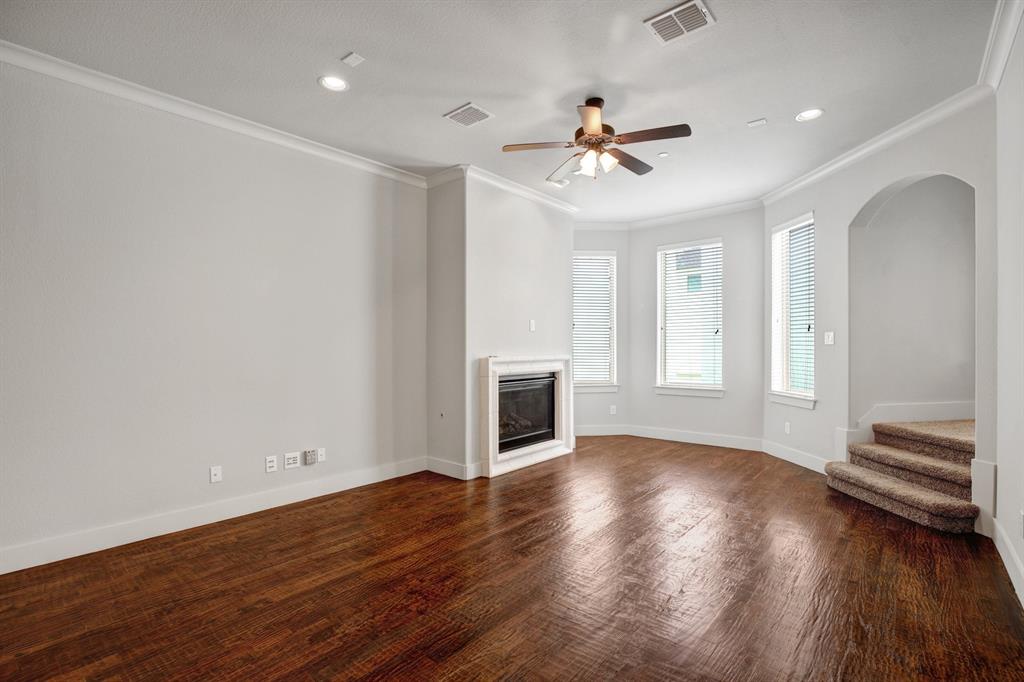 4111 Rawlins Street, Unit 403 Dallas, TX 75219 - Photo 6 of 23 Spacious living area featuring wood-finish flooring, a built-in fireplace with white surround, multiple windows with blinds, recessed lighting, and a ceiling fan