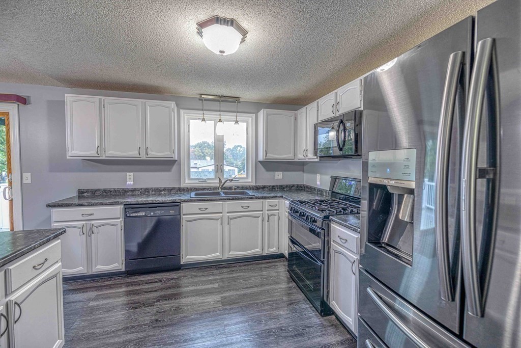 583 Wood Street Fall River, MA 02721 - Photo 13 of 32 a kitchen with stainless steel appliances granite countertop a refrigerator stove top oven and sink
