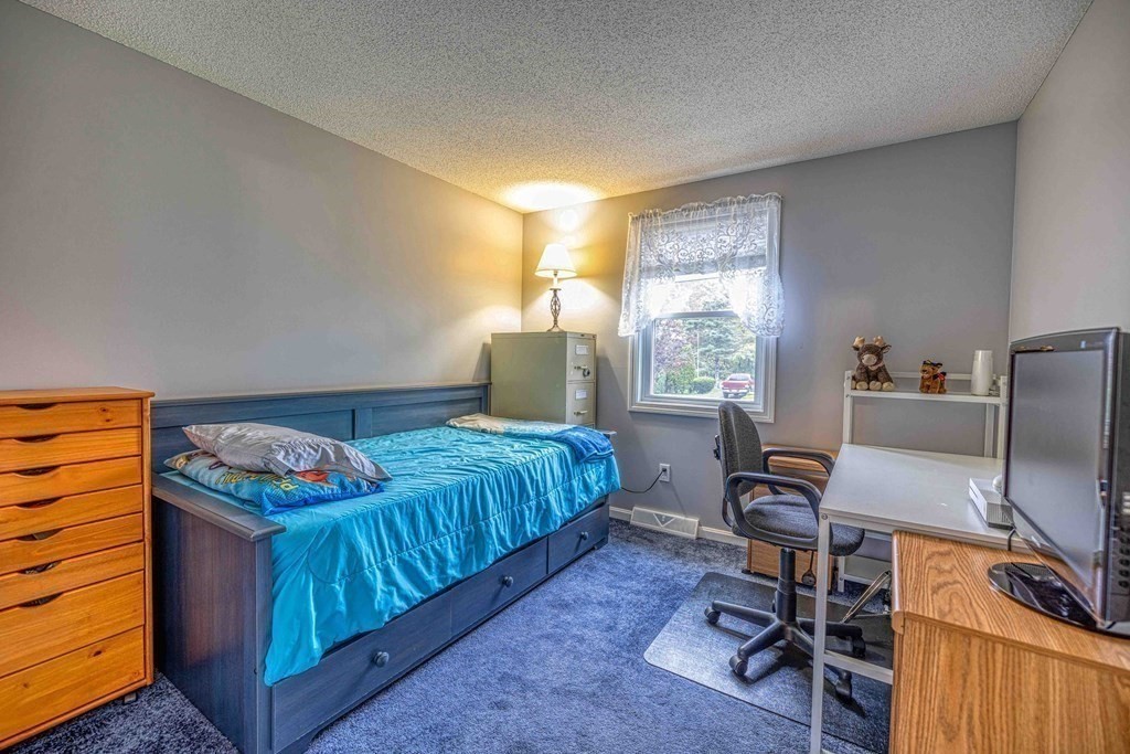 583 Wood Street Fall River, MA 02721 - Photo 18 of 32 a bedroom with a bed a computer on desk and a dresser next to a window