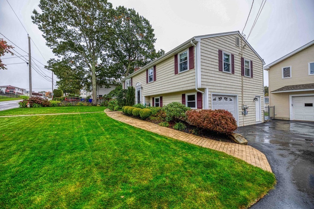 583 Wood Street Fall River, MA 02721 - Photo 4 of 32 a front view of a house with a garden and yard