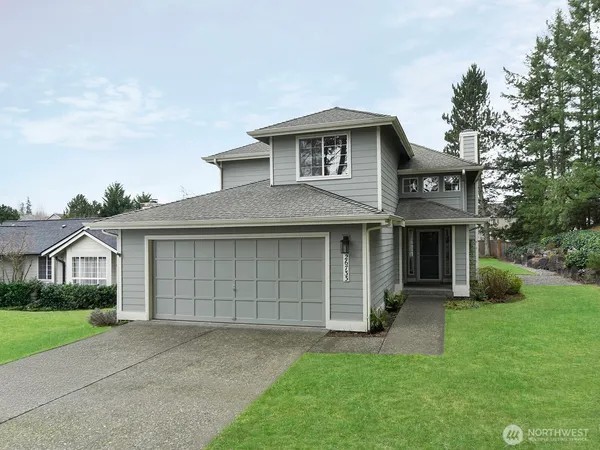 a front view of a house with a garden and garage