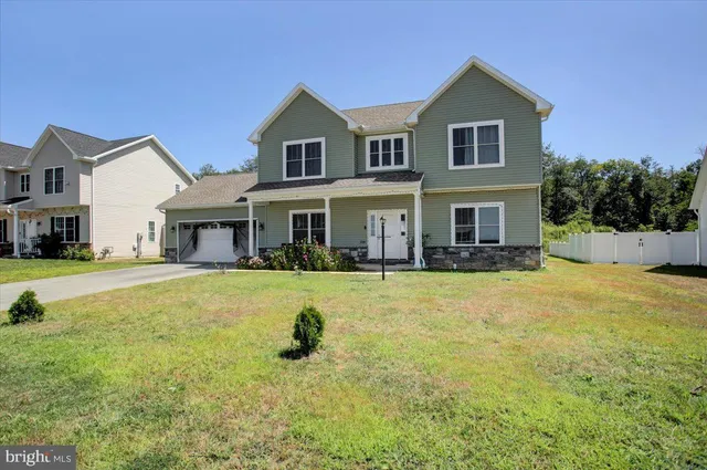 a front view of a house with a yard and trees