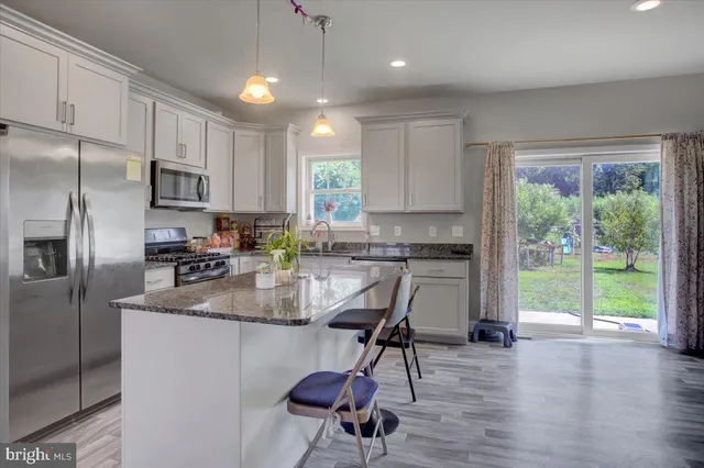 a kitchen with kitchen island a large counter top space appliances and cabinets