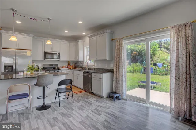 a kitchen with stainless steel appliances granite countertop counter space a stove and a wooden floors