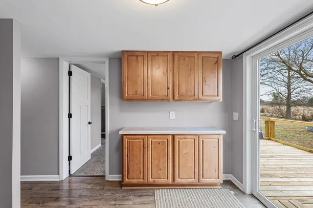 a view of a hallway with wooden floor and cabinet