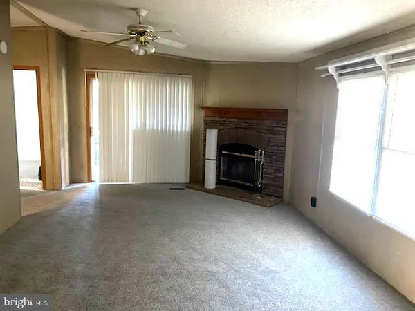 an empty room with windows and fireplace