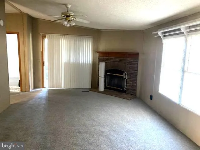 an empty room with windows and fireplace