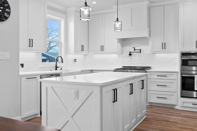 a kitchen with stainless steel appliances granite countertop a sink and cabinets