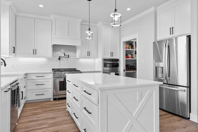 a kitchen with stainless steel appliances a refrigerator sink and cabinets