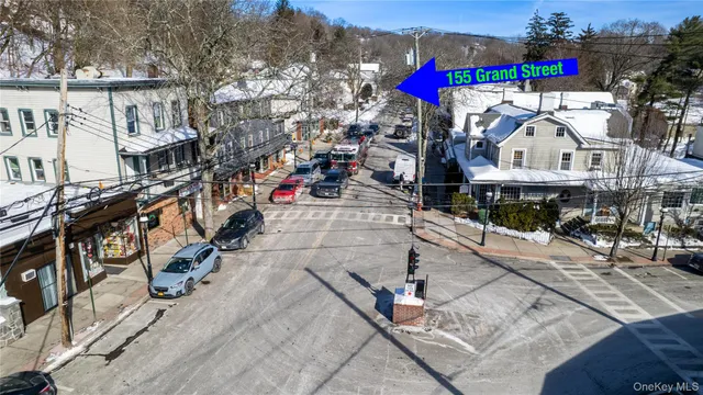 a street view with couple of cars parked on road in front of house