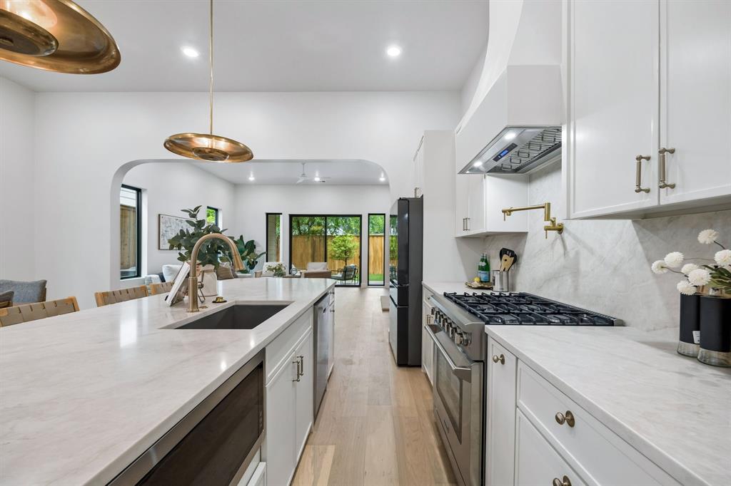 4615 Rusk Avenue Dallas, TX 75204 - Photo 8 of 25 a kitchen with kitchen island stainless steel appliances a sink a counter space and a view of living room