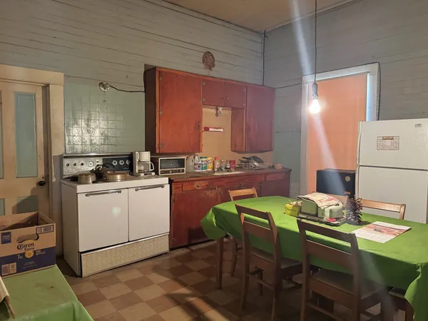 a kitchen with a table chairs and a refrigerator