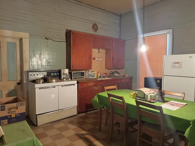 a kitchen with a table chairs and a refrigerator