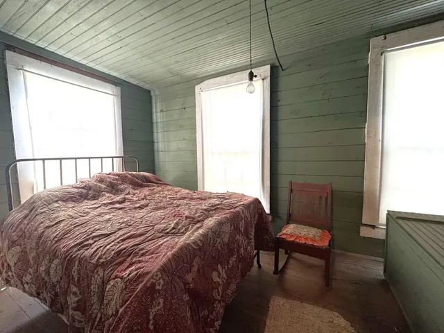 a bedroom with a bed chair and a window