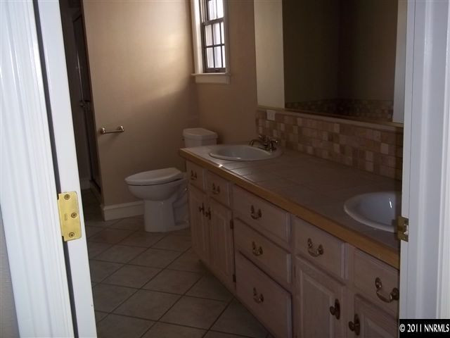 1000 Lampe Road Reno, NV 89511 - Photo 9 of 13 a bathroom with a granite countertop sink a toilet and a mirror