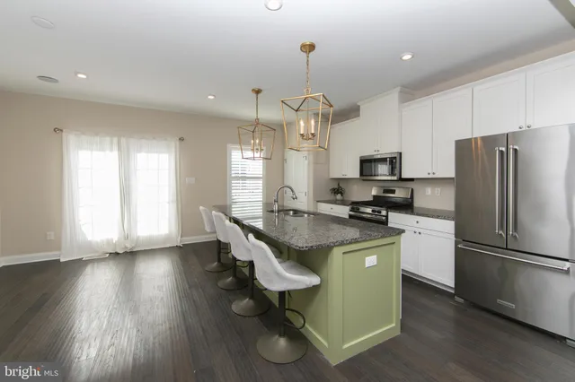 a kitchen with kitchen island white cabinets and stainless steel appliances