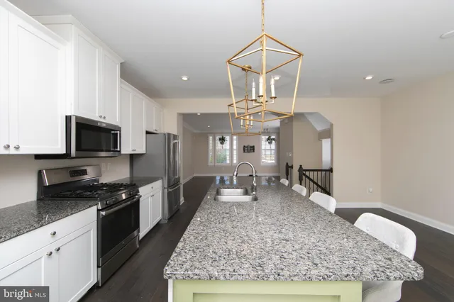 a kitchen with granite countertop a sink a counter top space appliances and cabinets