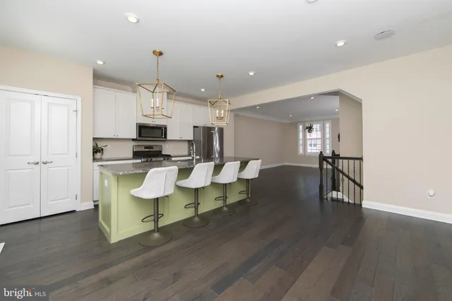 a open kitchen with white cabinets and stainless steel appliances