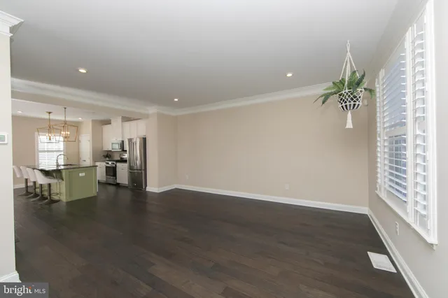 a view of empty room with wooden floor and a window