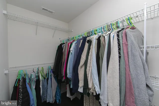a view of walk in closet with clothes