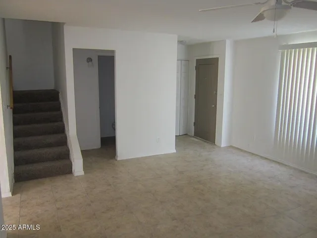 an empty room with a hallway and stairs