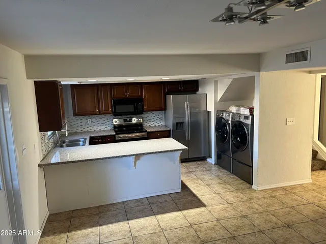 a kitchen with stainless steel appliances a refrigerator a stove and a sink