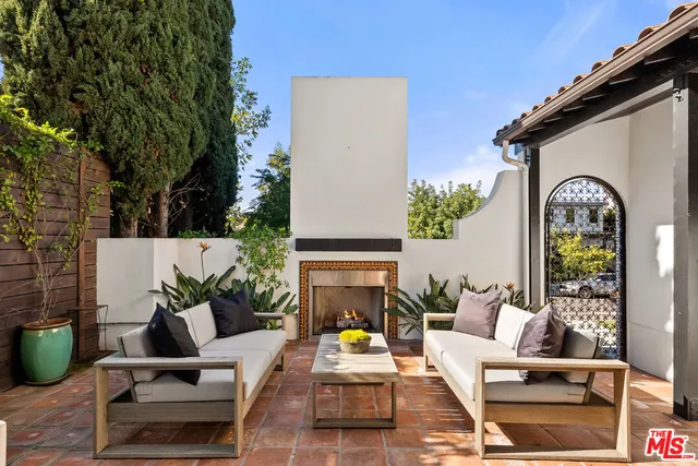 a living room with furniture a large window and a potted plant