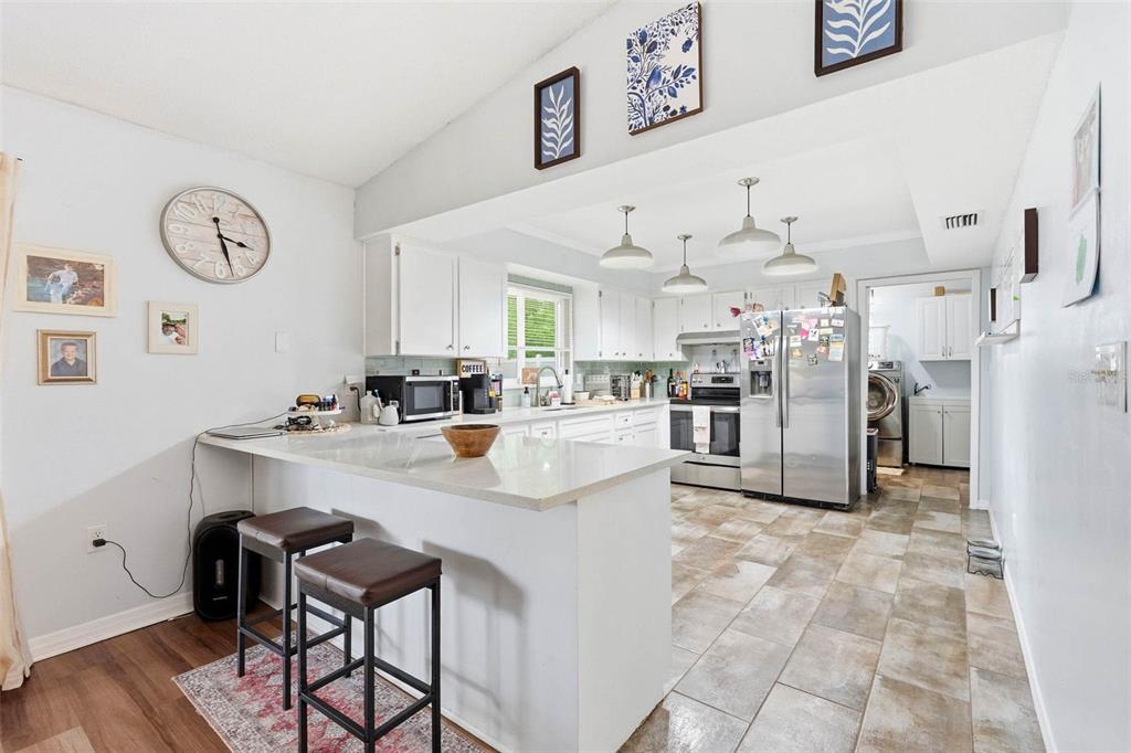 9062 Blackstone Street Spring Hill, FL 34608 - Photo 17 of 49 a kitchen with stainless steel appliances kitchen island granite countertop a sink and a refrigerator