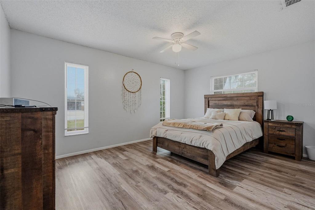 9062 Blackstone Street Spring Hill, FL 34608 - Photo 21 of 49 a bedroom with a bed and wooden floor