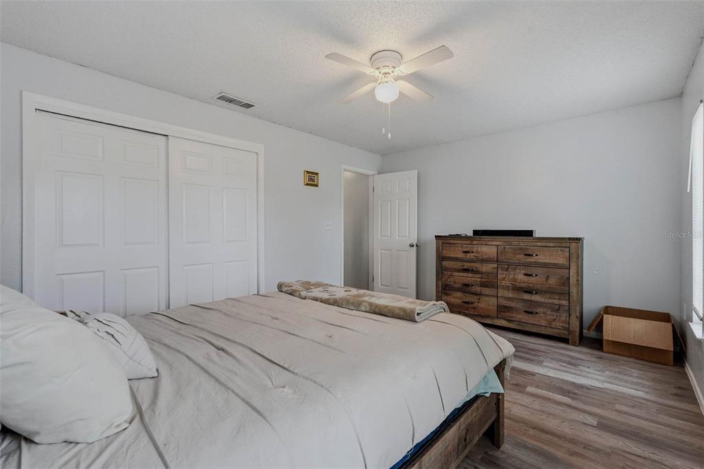 9062 Blackstone Street Spring Hill, FL 34608 - Photo 22 of 49 a bedroom with a bed and a chandelier