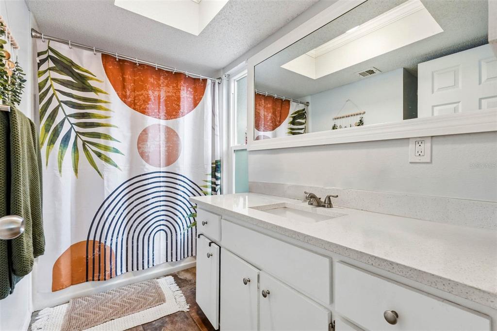 9062 Blackstone Street Spring Hill, FL 34608 - Photo 27 of 49 a bathroom with a sink a mirror and a bathtub
