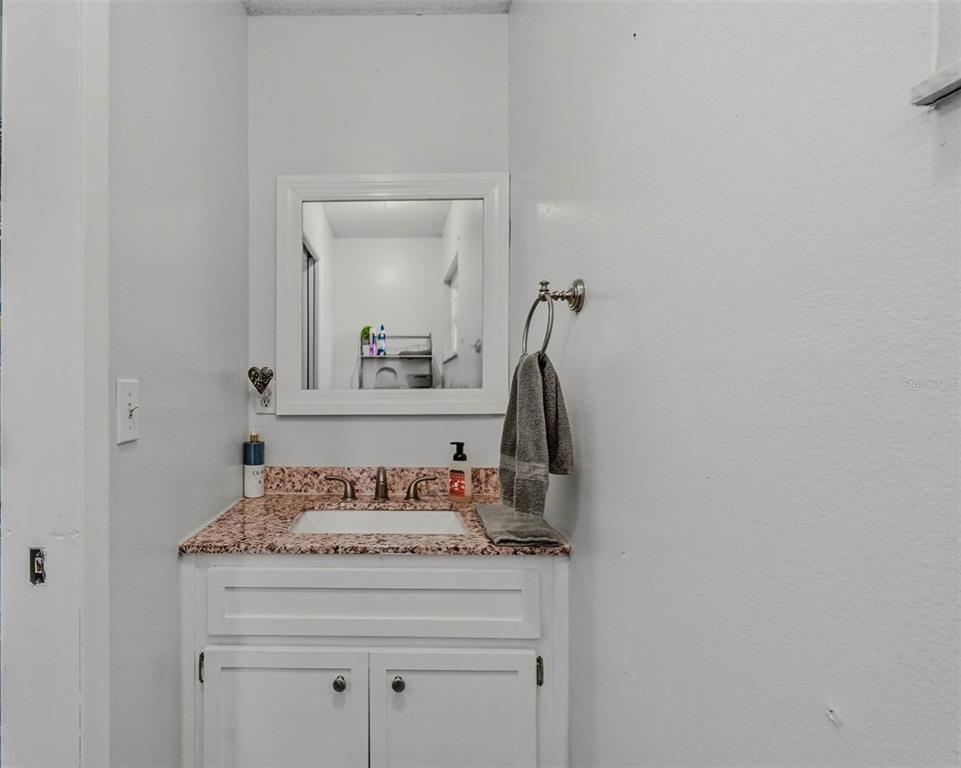 9062 Blackstone Street Spring Hill, FL 34608 - Photo 31 of 49 a bathroom with a granite countertop sink and a mirror