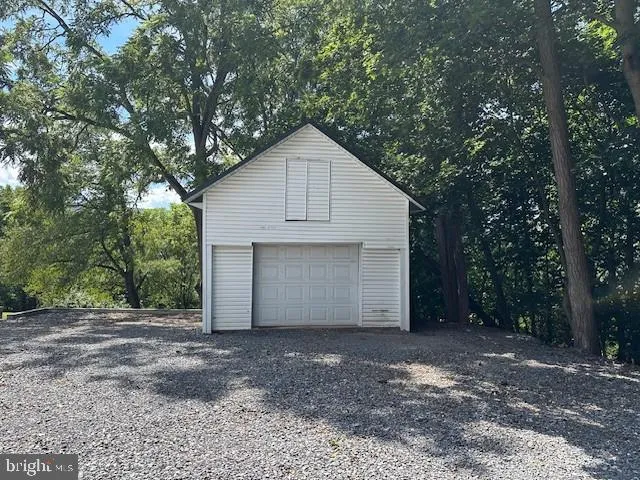 a view of a house with a yard and large tree
