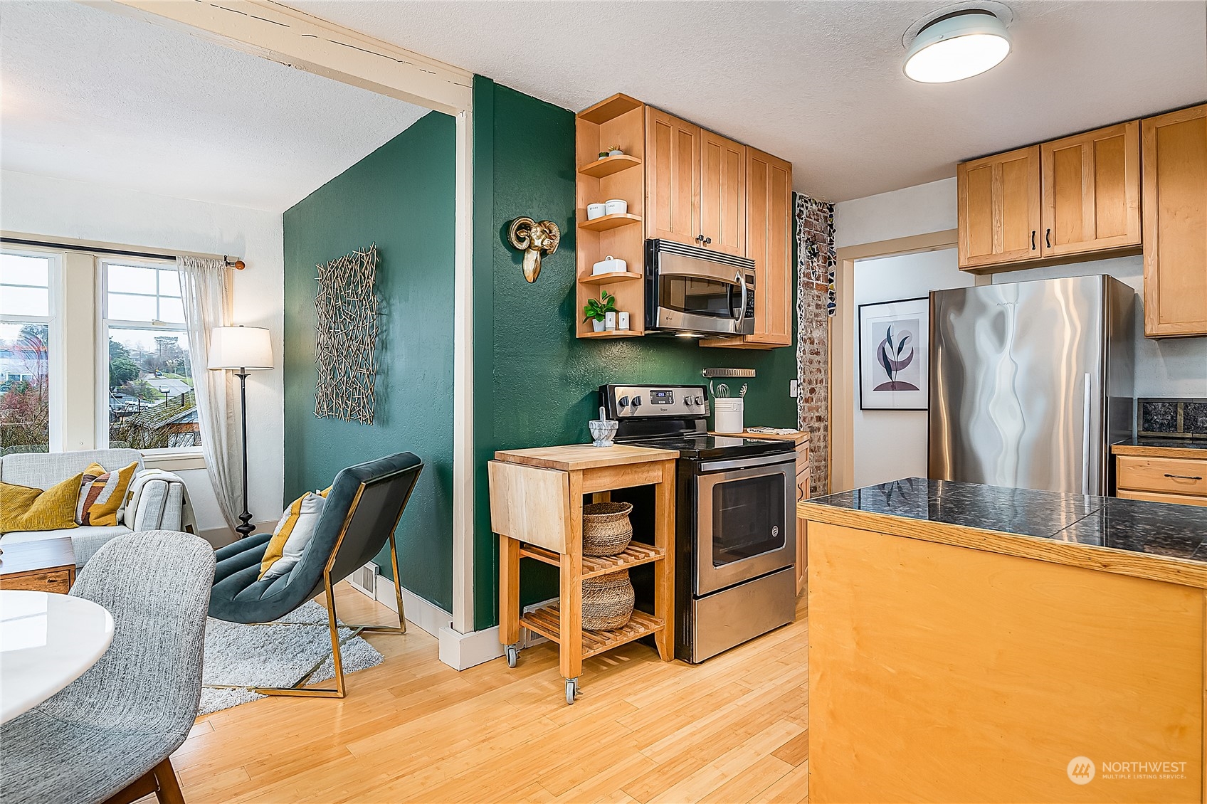 4100 Southwest Raymond Street Seattle, WA 98136 - Photo 8 of 23 a kitchen with stainless steel appliances a stove a refrigerator cabinets a dining table and chairs