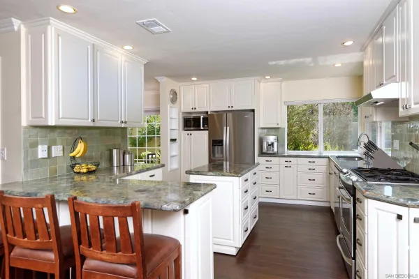 a kitchen with refrigerator a stove and chairs