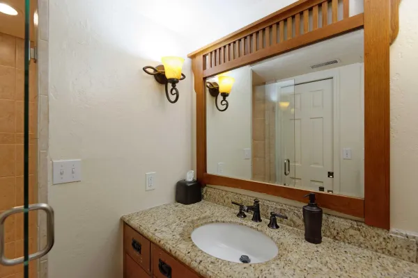 a bathroom with a granite countertop sink and a mirror