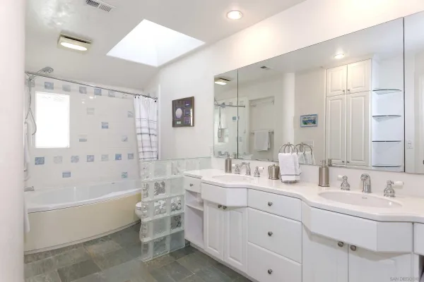 a bathroom with a double vanity sink mirror double and bathtub