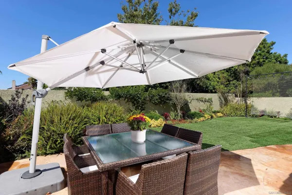 a view of a patio with table and chairs under an umbrella
