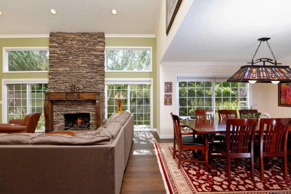 a living room with furniture a fireplace and a floor to ceiling window